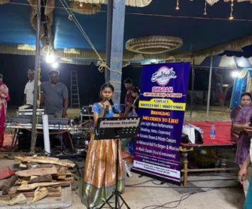 Young girl singing at temple event with music band setup