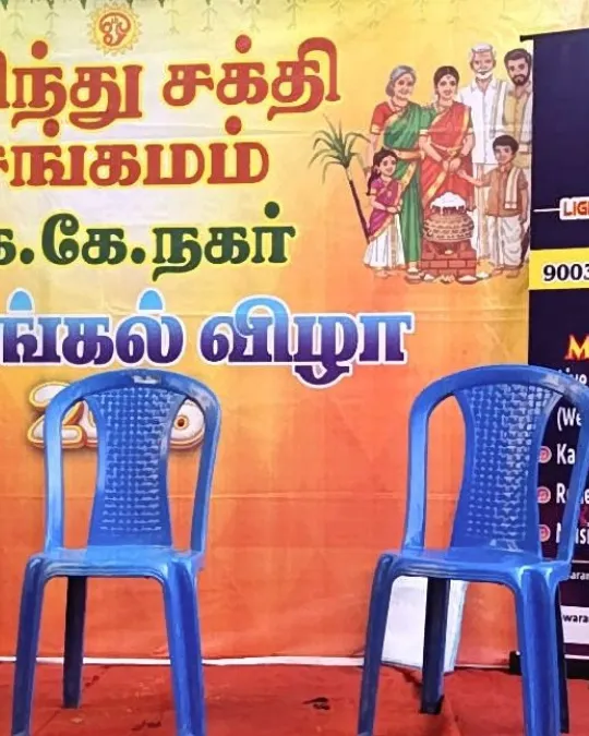 Empty stage chairs setup at cultural event with festival backdrop