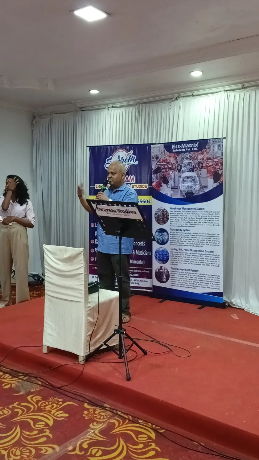 Man speaking on stage at live music program