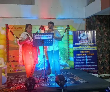 Man and woman singing duet on stage with mic setup