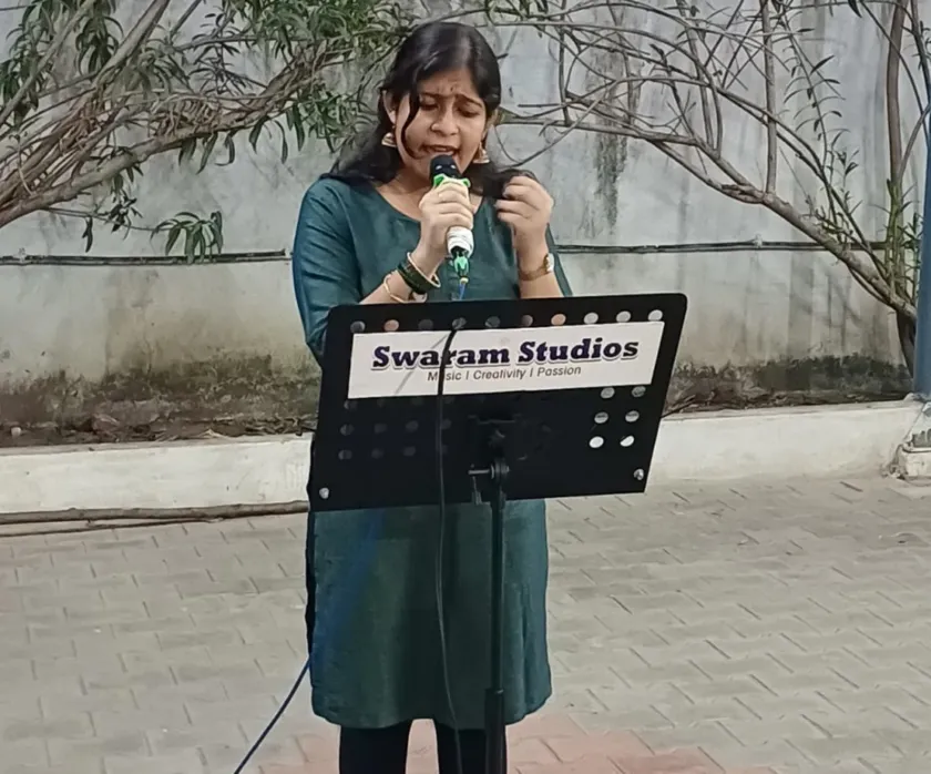 Woman singing outdoor with microphone and music stand