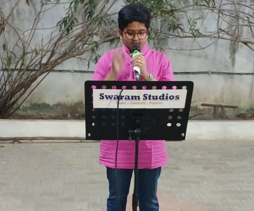 Boy speaking with microphone at outdoor music setup