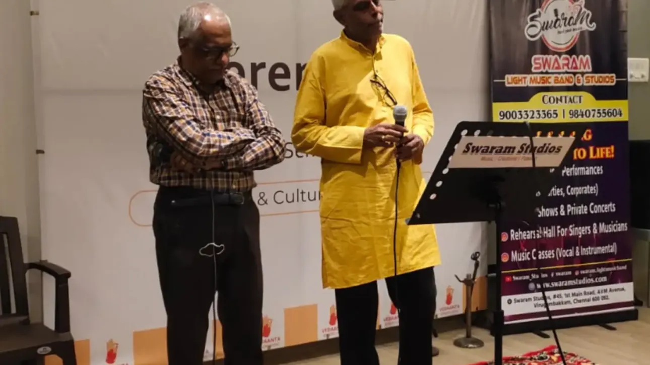 Two men speaking with microphone at indoor event stage