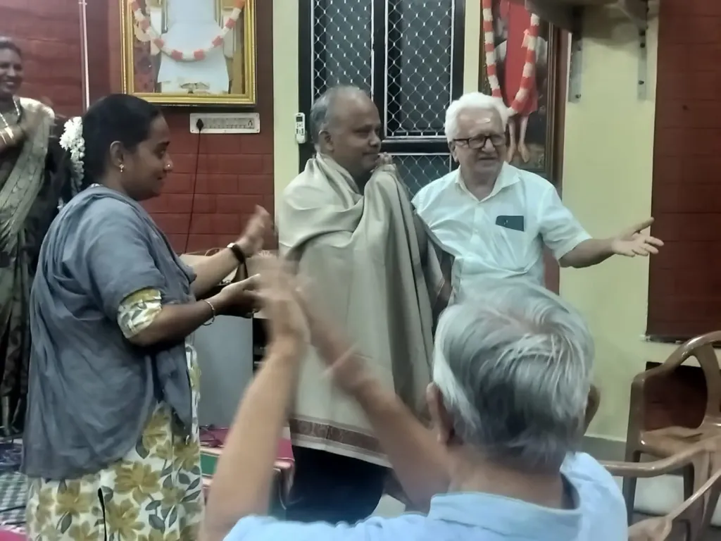 Man being honored with shawl at indoor cultural event