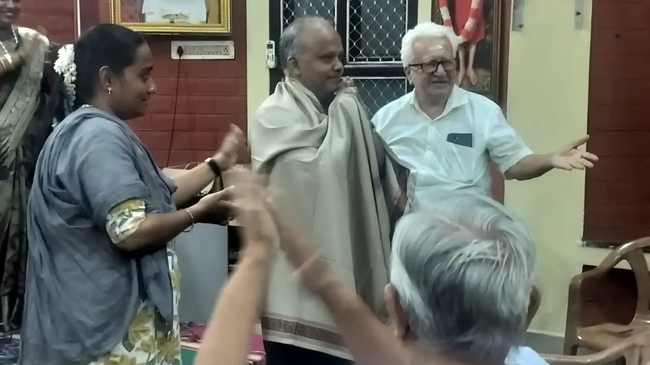 Man being honored with shawl at indoor cultural event