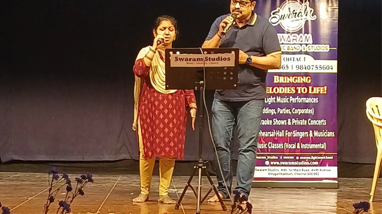 Man and woman singing on stage at live music event