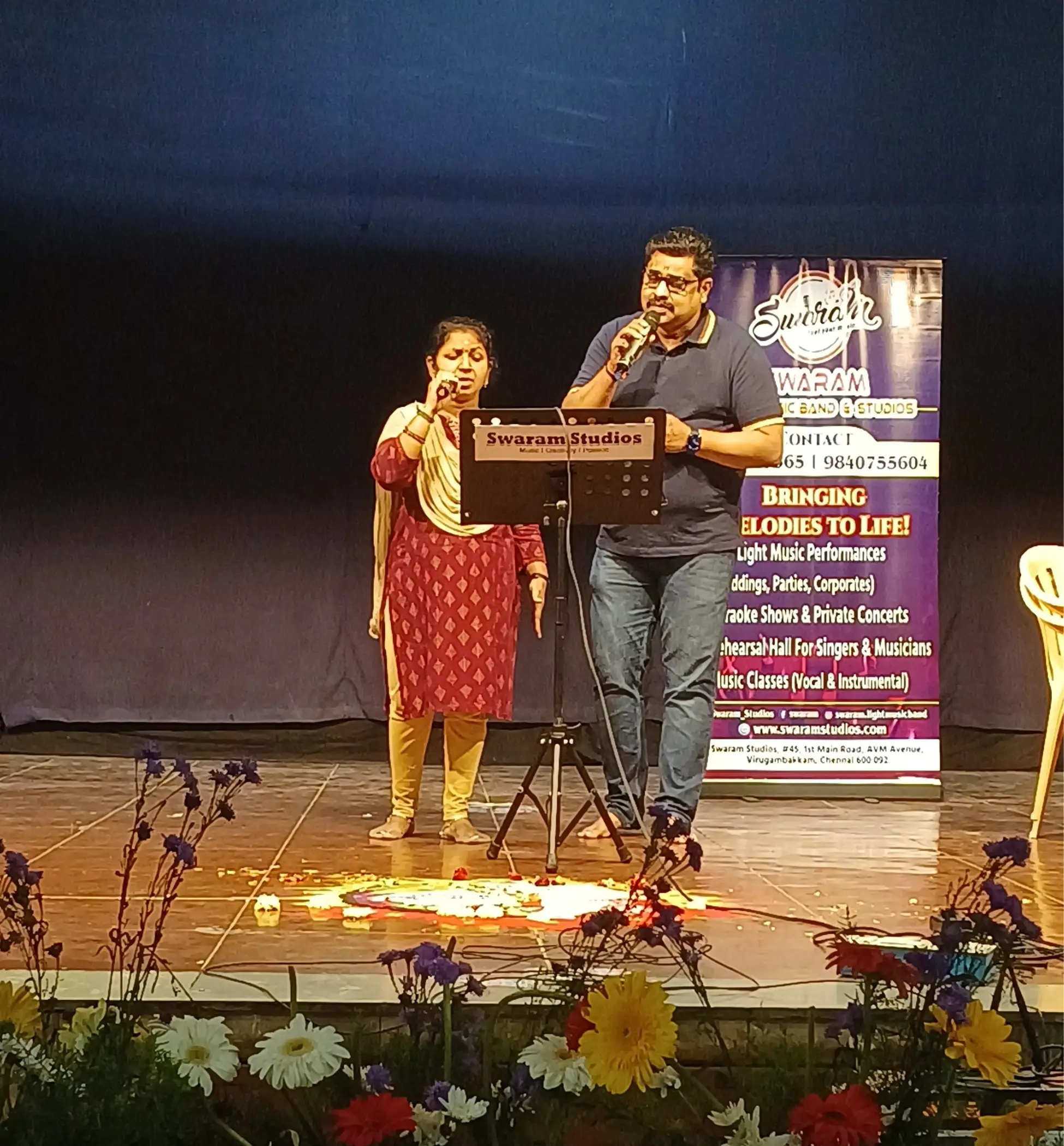 Man and woman singing on stage at live music event